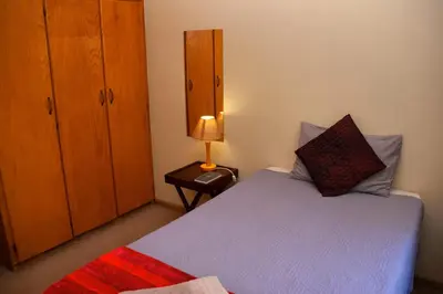 a bedroom with a bed and a lamp on a table at Cairos Guest House in Witbank