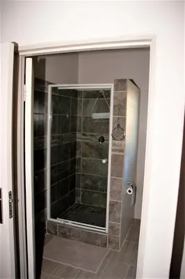 a shower with a glass door in a bathroom at Cairos Guest House in Witbank