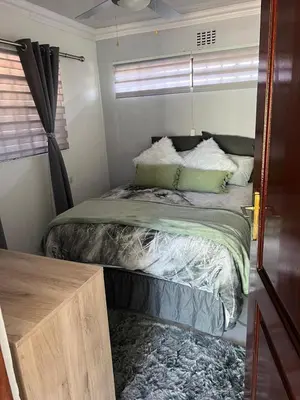a bed in a small room with a window at 22 impala Ave in Kempton Park