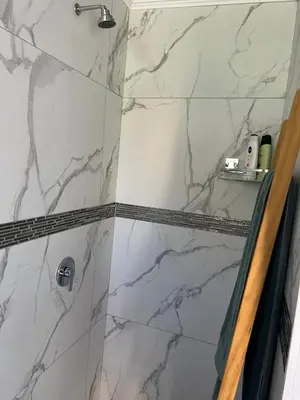 a bathroom with a shower with white marble tiles at 22 impala Ave in Kempton Park