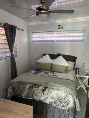 a bedroom with a bed and a ceiling fan at 22 impala Ave in Kempton Park