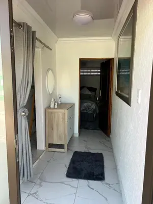 a bedroom with a bed and a dresser and a mirror at 22 impala Ave in Kempton Park