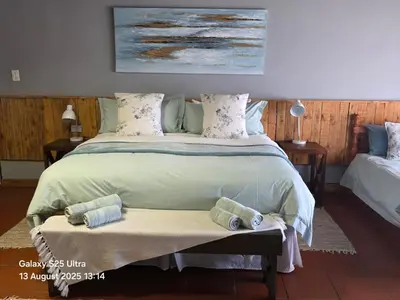 a bedroom with a large bed with towels on it at Veldjie Huis in Temba