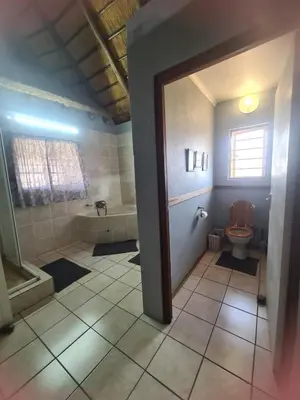 a bathroom with a toilet and a bath tub at Veldjie Huis in Temba