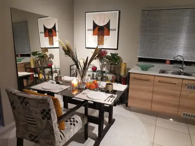 a kitchen with a table and chairs and a sink at The Centurion Sunset in Centurion