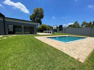 a house with a swimming pool in a yard at The Centurion Sunset in Centurion