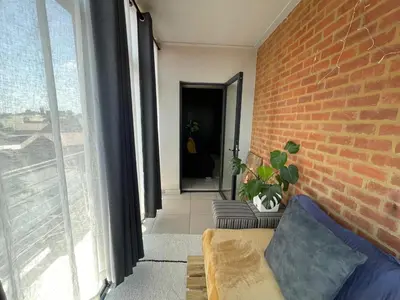 a living room with a brick wall and a couch at The Centurion Sunset in Centurion