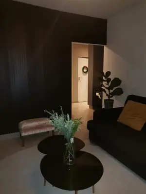 a living room with a black couch and a table at The Centurion Sunset in Centurion