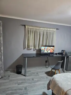 a desk with a computer on it in a bedroom at Lanico in Witbank