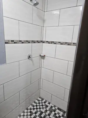a bathroom with a shower with a checkered floor at Lanico in Witbank