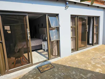 a room with sliding glass doors and a bedroom at Lanico in Witbank