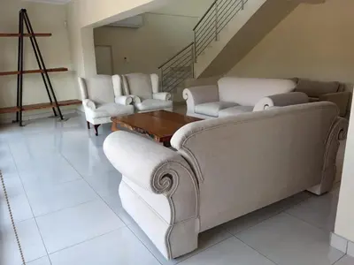 a living room with couches and a table and stairs at Wildlife Oasis in Marloth Park
