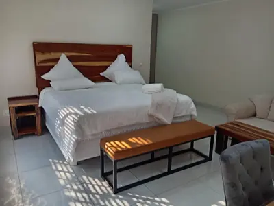 a bedroom with a bed and a table and a couch at Wildlife Oasis in Marloth Park