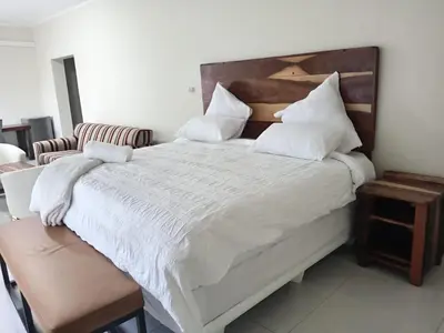 a bedroom with a large bed with white sheets and pillows at Wildlife Oasis in Marloth Park