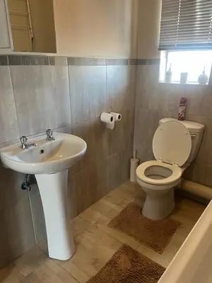 a bathroom with a toilet and a sink at Modern Style Apartments, An Escape From The City in Pretoria