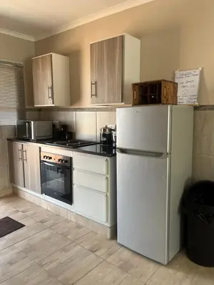 a kitchen with white appliances and a white refrigerator at Modern Style Apartments, An Escape From The City in Pretoria