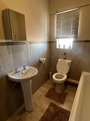 a bathroom with a toilet and a sink at Modern Style Apartments, An Escape From The City in Pretoria