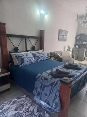 a bedroom with a bed with a blue comforter at Ormonde guesthouse in Pretoria