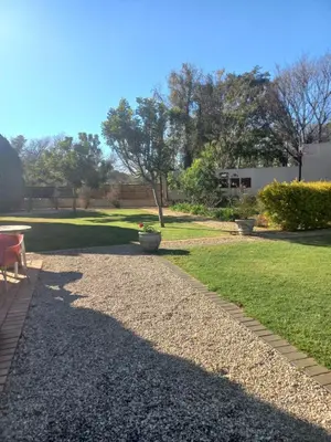 a gravel walkway with two vases in a yard at Ormonde guesthouse in Pretoria