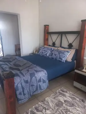a bedroom with two beds with blue comforter at Ormonde guesthouse in Pretoria