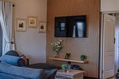 a living room with a tv on a striped wall at Nature's Nest in Pretoria