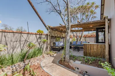 a backyard with a pergola and a tree at Nature's Nest in Pretoria