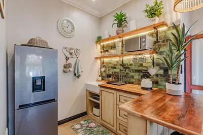 a kitchen with a refrigerator and a wooden counter at Nature's Nest in Pretoria