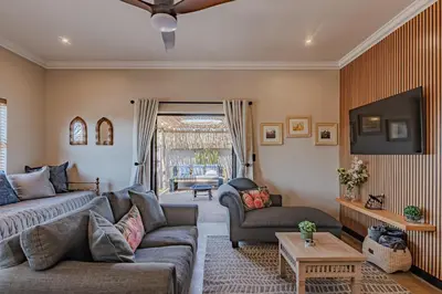 a living room with a couch and a tv at Nature's Nest in Pretoria