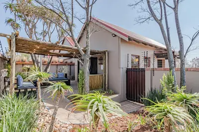 a home with a porch and a fence at Nature's Nest in Pretoria