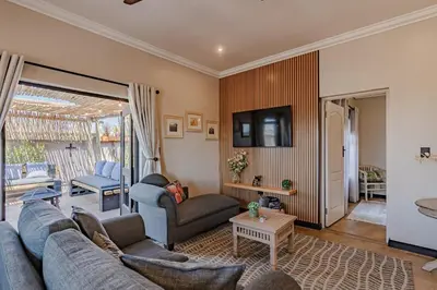 a living room with two couches and a tv at Nature's Nest in Pretoria