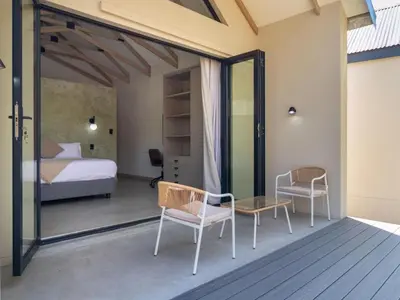 a bedroom with a bed and a table and chairs at Wabi Sabie River House in Hazyview