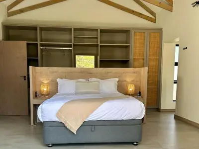 a bedroom with a large bed with shelves at Wabi Sabie River House in Hazyview