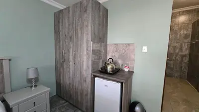 a bathroom with a tea kettle on top of a wooden wall at The Magalies Nest - Self Catering Accomodation in Hartbeespoort