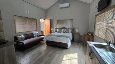 a bedroom with a bed and a couch at The Magalies Nest - Self Catering Accomodation in Hartbeespoort