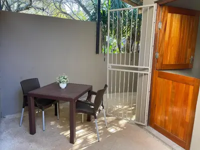 a table and chairs in a room with a gate at The Magalies Nest - Self Catering Accomodation in Hartbeespoort