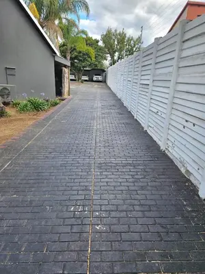 a brick sidewalk next to a white fence at Bella Cottage in Centurion