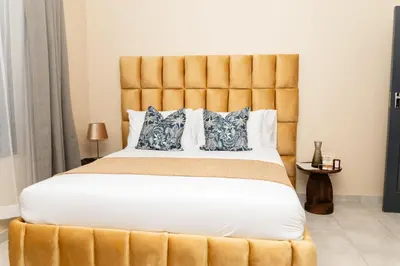 a bedroom with a large bed with a large headboard at Hamisi Manor Guest House in Midrand