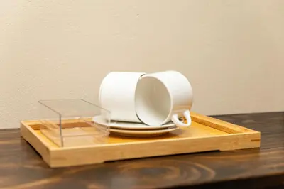two white coffee cups sitting on a wooden tray at Hamisi Manor Guest House in Midrand