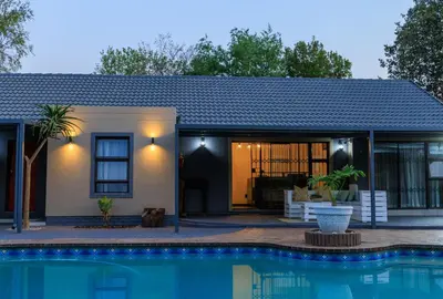 a house with a pool in front of it at Hamisi Manor Guest House in Midrand