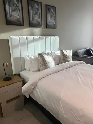 a white bed with a white headboard in a bedroom at 423 Menlyn maine Apartment in Pretoria