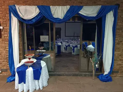 a set up for a banquet with blue drapes and tables at Oppiplot Guest House Pty Ltd in Kempton Park