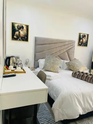 two beds in a room with a desk and a bed at Marble Nights Guesthouse and spa Elim in Elim