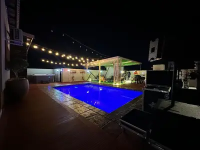 a swimming pool at night with a gazebo at Marble Nights Guesthouse and spa Elim in Elim
