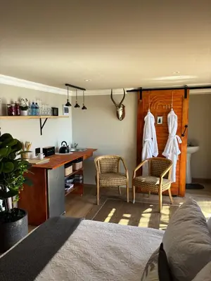 a room with a kitchen with a table and chairs at Harties Damview Resort in Hartbeespoort