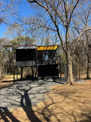a shadow of a tree and a bus stop at Harties Damview Resort in Hartbeespoort