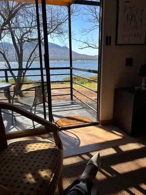 a room with a window with a view of the water at Harties Damview Resort in Hartbeespoort