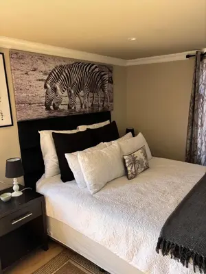 a bedroom with a bed with a painting of zebras at Harties Damview Resort in Hartbeespoort