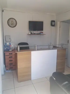 a room with a desk with a tv on the wall at Christland Guest House in Kempton Park
