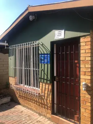 a building with a gate in front of it at Christland Guest House in Kempton Park