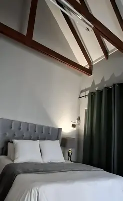 a bedroom with a large bed with green curtains at Apartment 1 at CView in Pretoria